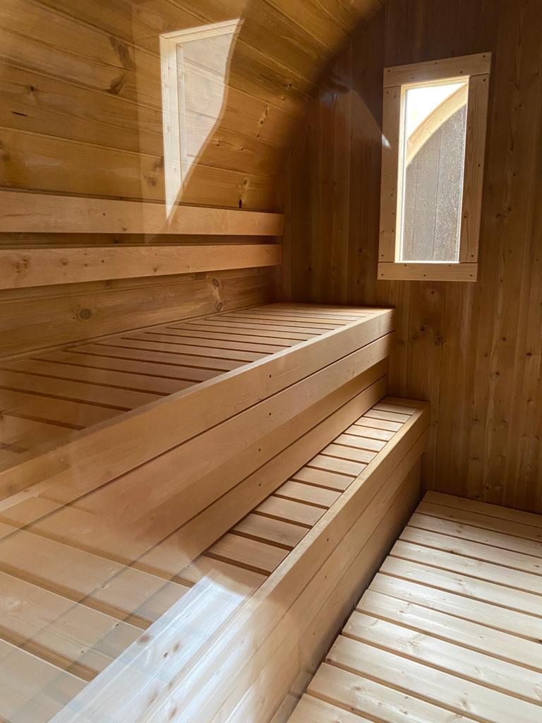 Liegebank aus Holz in einem Saunafass